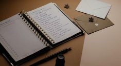 A tidy desk setup featuring a planner, to-do list, envelopes, and a pen.