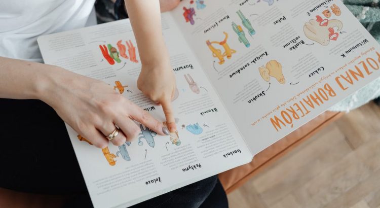 A child and adult engaging with an educational book, pointing to illustrations.